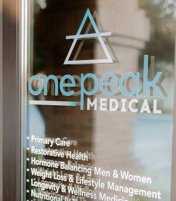 Front door that says, "onepeak medical, primary care, restorative health, hormone balancing men & women, weight loss and lifestyle..."