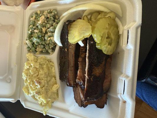 Two meat plate with brisket , ribs, potato salad and pea salad.