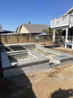 Coping, fire pit, stone and tile complete.