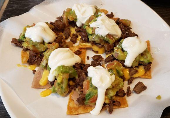 Half order of Mexican style nachos ($8.20): steak, beans, queso, guacamole & sour cream on individual chips