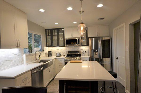 We removed the peninsula and built custom cabinetry with an island, bigger window, nicer lighting, marble and quartz with apron sink