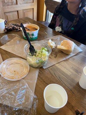 Small Caesar salad, small soup and half eaten loaf