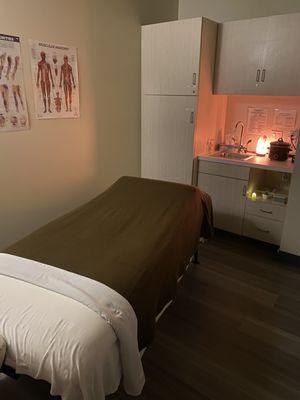 Massage room - warm, soft lighting, clean room and bed