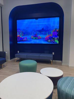 Waiting area has a big video fish tank