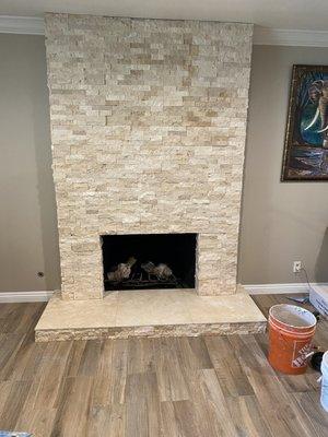 Porcelain panels on the floor and stack stone pm the fireplace.