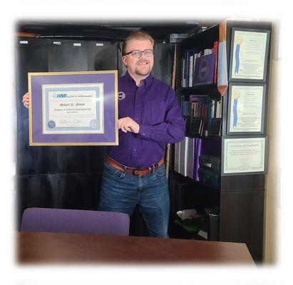 Michael D. Milson, CC.Ht, CAHA, MPNLP holding his Diploma in Clinical Hypnotherapy with Honors.