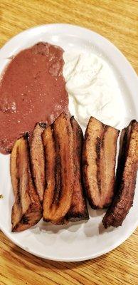 Fried plantains with refried beans and cream