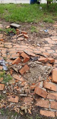 Two of the four holes left in my brick driveway from dumpster delivery.