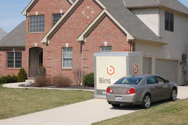 Bins container placed in a two car driveway and vehicle able to easily drive by.