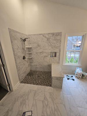 Up close view of a custom-built tile shower with seating.