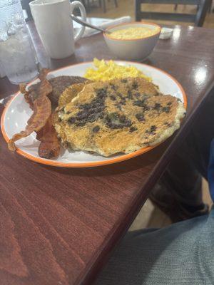 Bacon, sausage, eggs and blueberry pancakes with grits