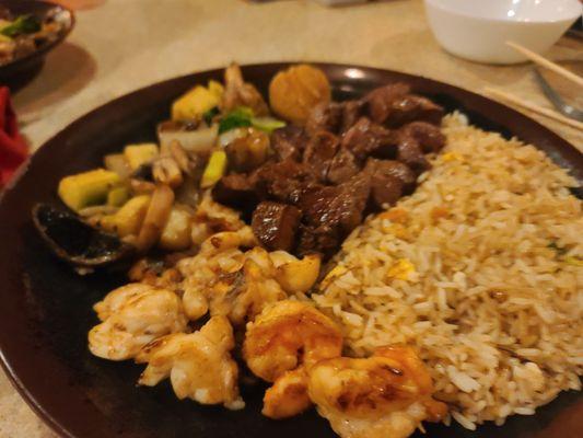 Steak, lobster, shrimp, fried rice, vegetables, and scallops.