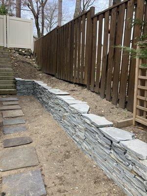 Installed a dry stack bluestone colonial wall 13 a small slope between a neighboring property