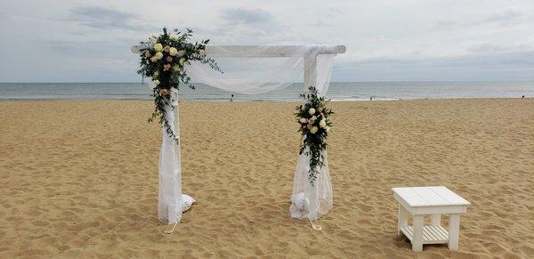 A beautiful beach wedding where we designed and installed 2 flower sprays and fabric on our arch.