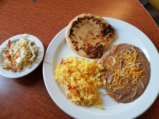 Shredded pork and cheese pupusa with rice, beans and coleslaw.