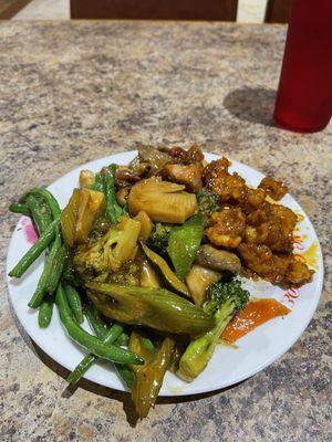 A selection of green beans, beef with mushrooms, mixed vegetables, and sesame chicken.