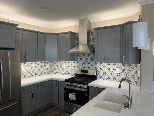 Grey shaker cabinets with modern backsplash can bring life to your basic kitchen.