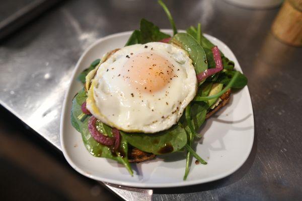 The Careless Whisper Avocado Toast. Aioli, Hummus, Spinach, EVOO, Balsamic, Pickled Red Onion.  W/ added egg.