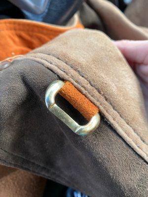 Reattached buckle strap to the coat.