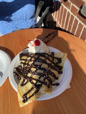 French crape with vanilla ice cream, hot chocolate sauce, whipped cream and a cherry.