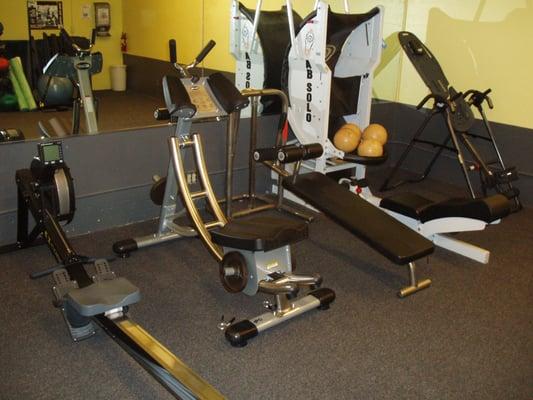 New rowing macine next to new ab coaster, thick padded decline bench for situps and ab solo and inversion table.