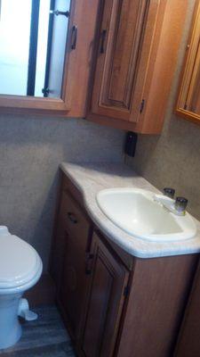 Enclosed bathroom area full of cabinets, sink and toilet all available.