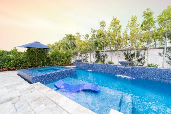 Contemporary blue tile pool and spa with Baja shelf