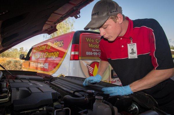 Technician working on customer's vehicle at their work location.