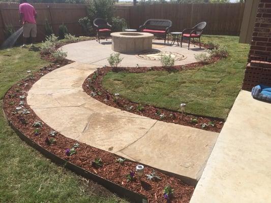 This is a picture after we installed the edging, shrubs, flowers, and sod. The customers were very happy with the results!