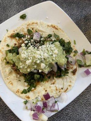 Beef brisket taco with queso fresco, cilantro, poblano crema and the red onions (not a fan, that's just me).