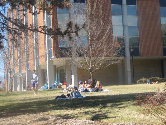 Sunny day at SLU! Students hang out in front of the library on blankets.