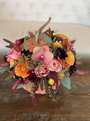 Fresh pumpkin hollowed out and filled with fall flowers!