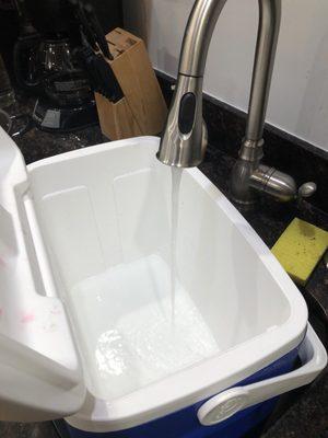 Filling up my cooler with hot water from the kitchen sink