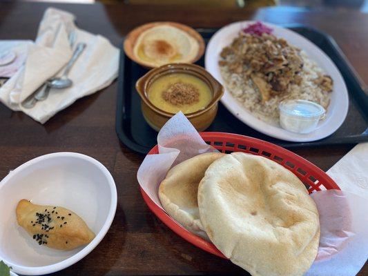 Chicken Shawarma Over Rice with lentil soup and hummus.  One olive bread bite.