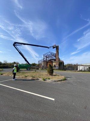 This project involves high-reach demolition of a chimney at a World War II-era factory in Far Rockaway, NY.