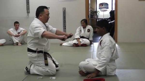 Sensei presenting Black Belt to Student