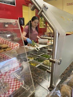 The young lady piling the sandwich on. The owner's special Olive Tapenade in tow