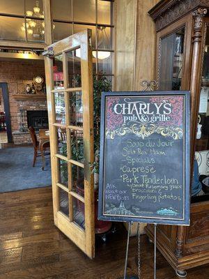 Sign in lobby of Weatherford Hotel advertising Charly's. The main dining area is to the left. The main bar is to the right.