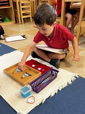 Primary student working on additions with the colored bead bars.