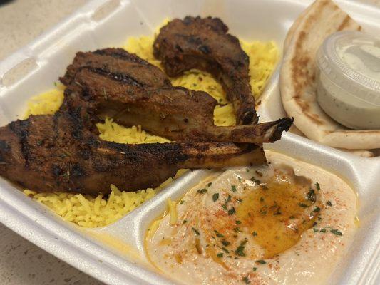 3 Piece Lamb Chops, (garlic, rosemary, thyme, olive oil, grilled) served with Hummus, Pita Bread, and Rice.