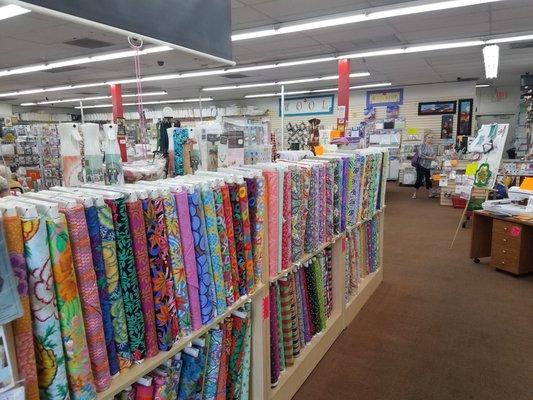 Rows of quilt fabric over 5,000 bolts to choose from. Selection is always changing and over 80% of the fabric is $6.95 a yard always.