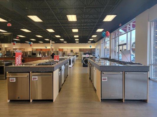 Appliance showroom with dishwashers and stove tops on display