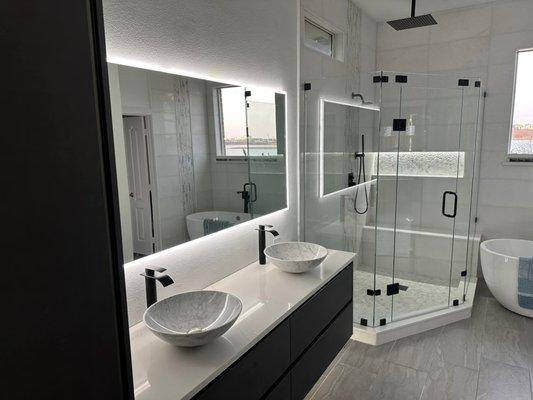 Custom built floating linnen cabinet and vanity with double marble bowl sinks and quartz countertop.