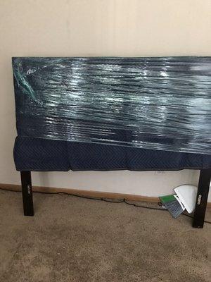 Leather and wood headboard. Fully protected, covered by moving blankets and shrink wrap.