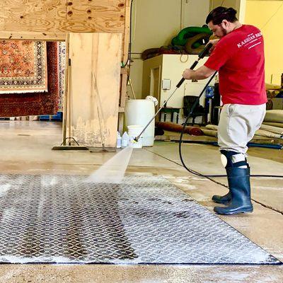 Cleaning rugs in our Evanston warehouse