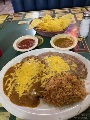 Two enchiladas with salsa in background.