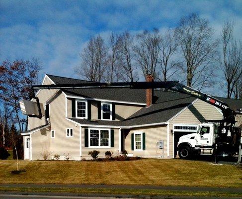 Crane delivery of drywall to homes.