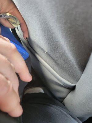 This is my husband pointing out the wire that cut his pants when he got in the car