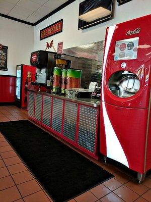 Drink station with fresh brewed iced teas, water, ice and variety of coke products.