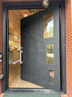 The front side of this custom pivot door that is 6 feet wide and 8 feet high made of solid steel.